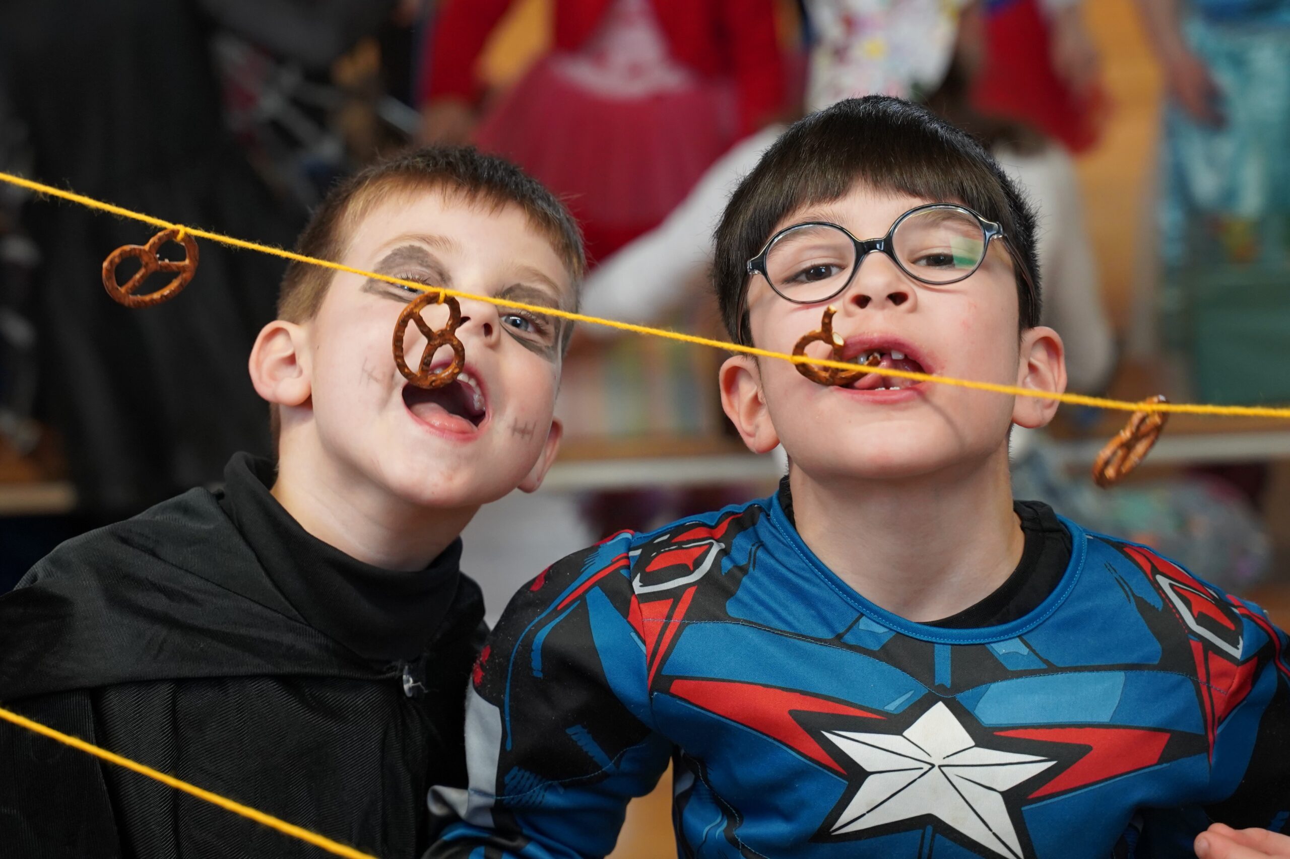 Kinder beim Brezel-Schnappen an einer Schnur