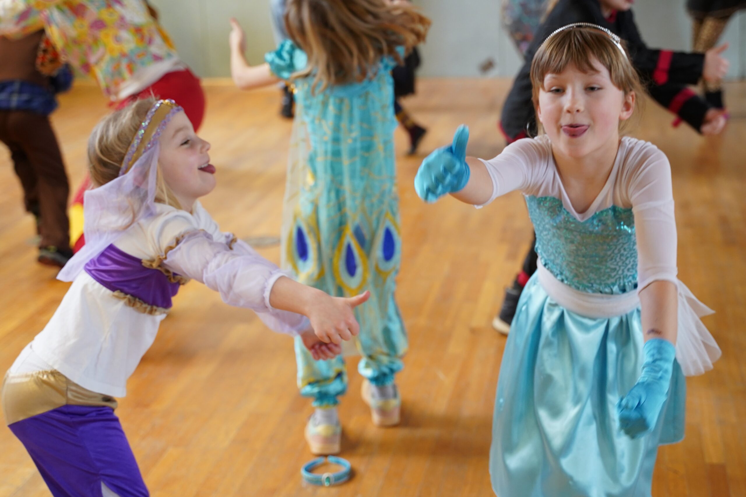 Kinder in Kostümen spielen und tanzen in der Halle